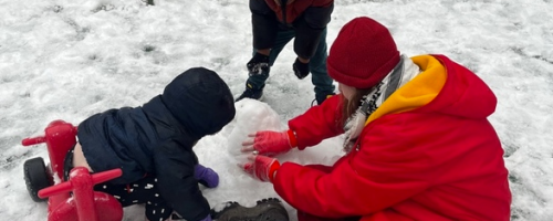 Preschoolers building a snowman