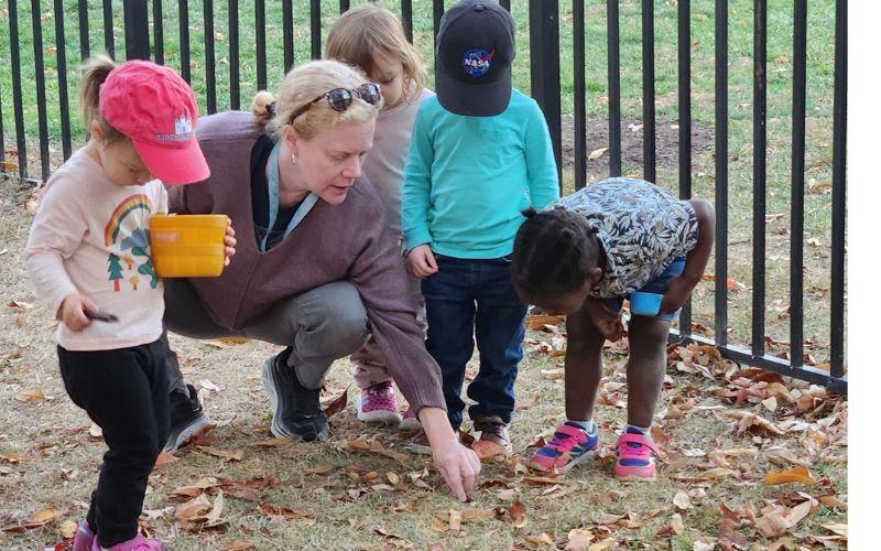 Teacher collecting leaves with children