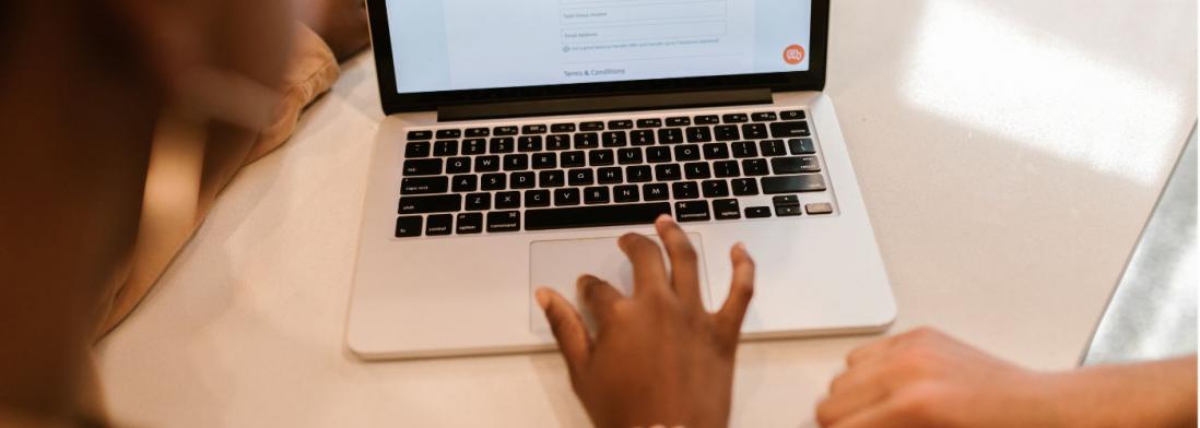 Hands filling out form on a computer