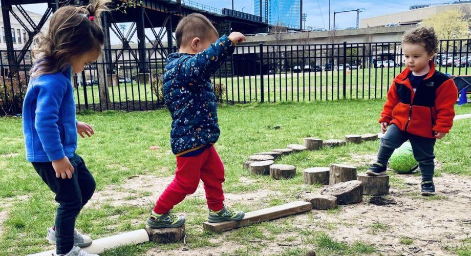 Toddlers playing outside on balance blocks 